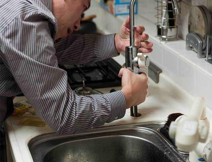 Plumber fixing a sink | West Sussex Drains