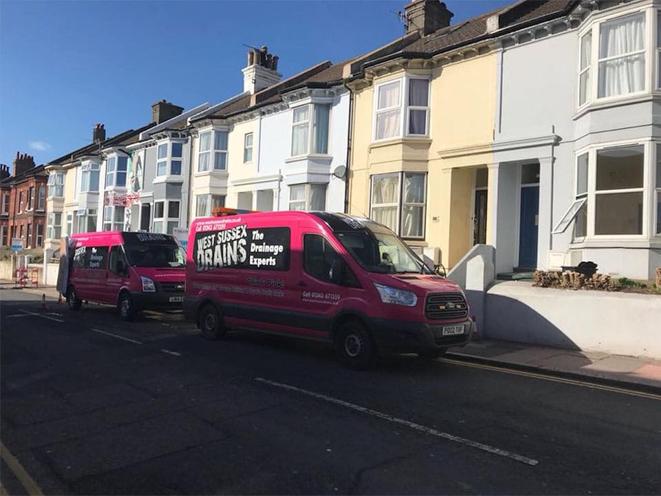 West Sussex Drains pink vans in street
